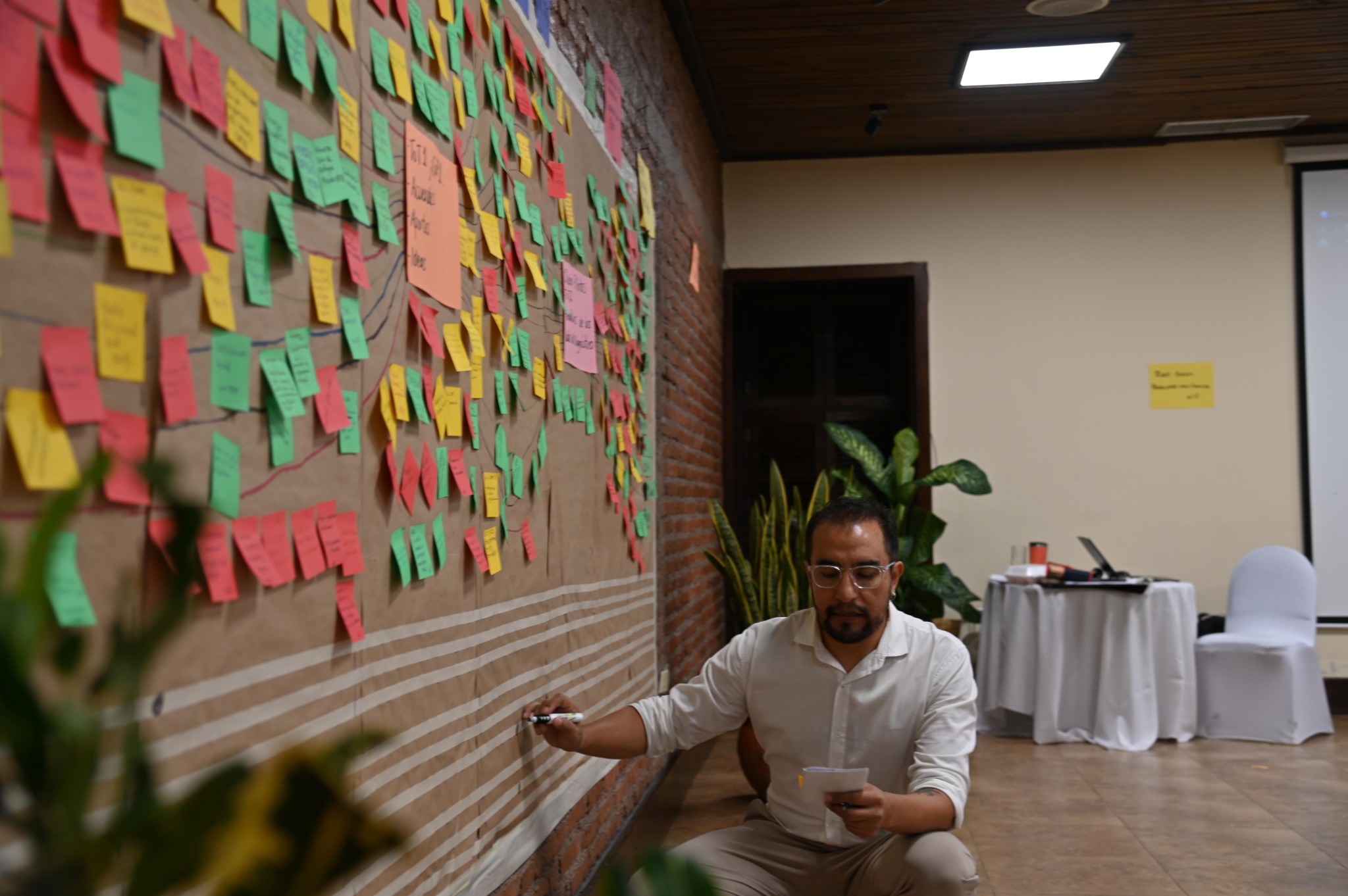 Facilitando un proceso participativo junto a un mural de trabajo colectivo